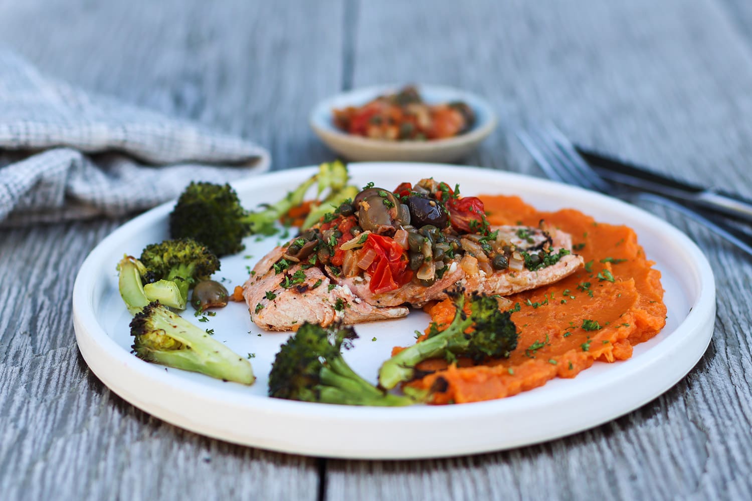 Grilled Arctic char filet with yam puree, roasted broccoli, and an olive, caper and tomato salsa.