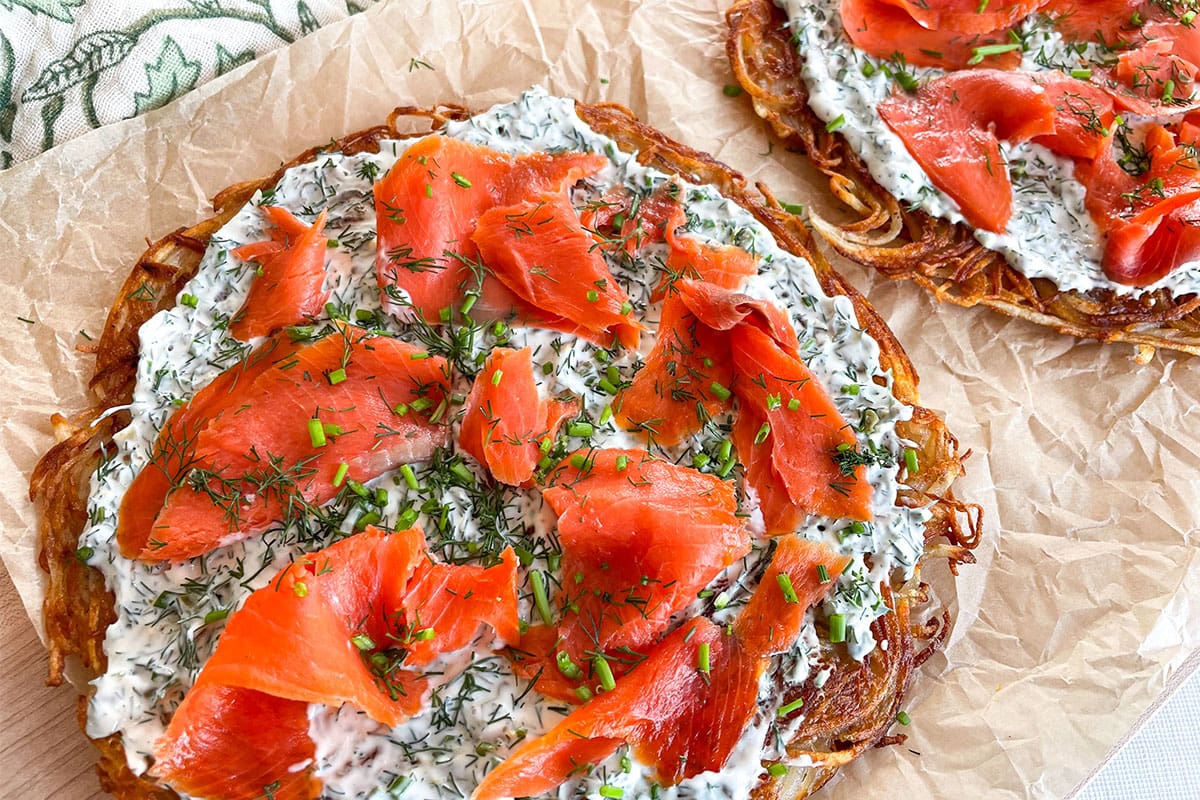 Two crispy potato galettes topped with herb cream and smoked sockeye salmon lox.