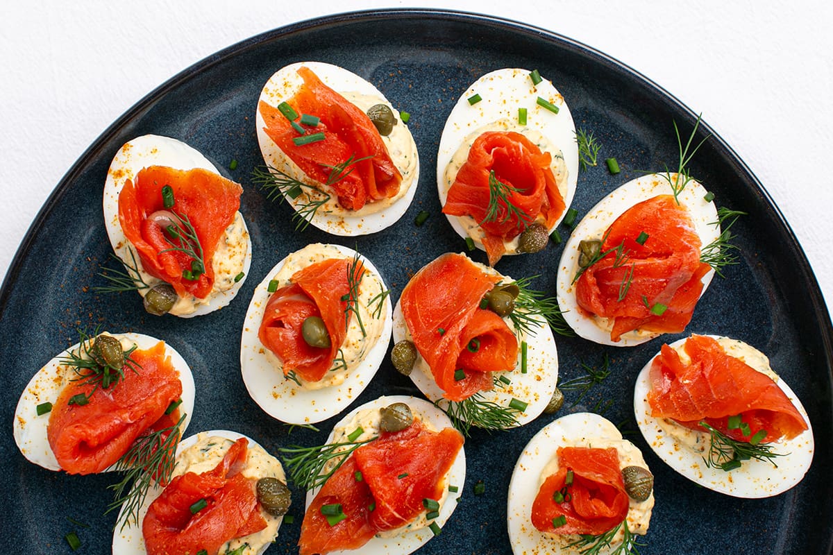 Deviled eggs topped with smoked sockeye salmon lox, capers and dill.