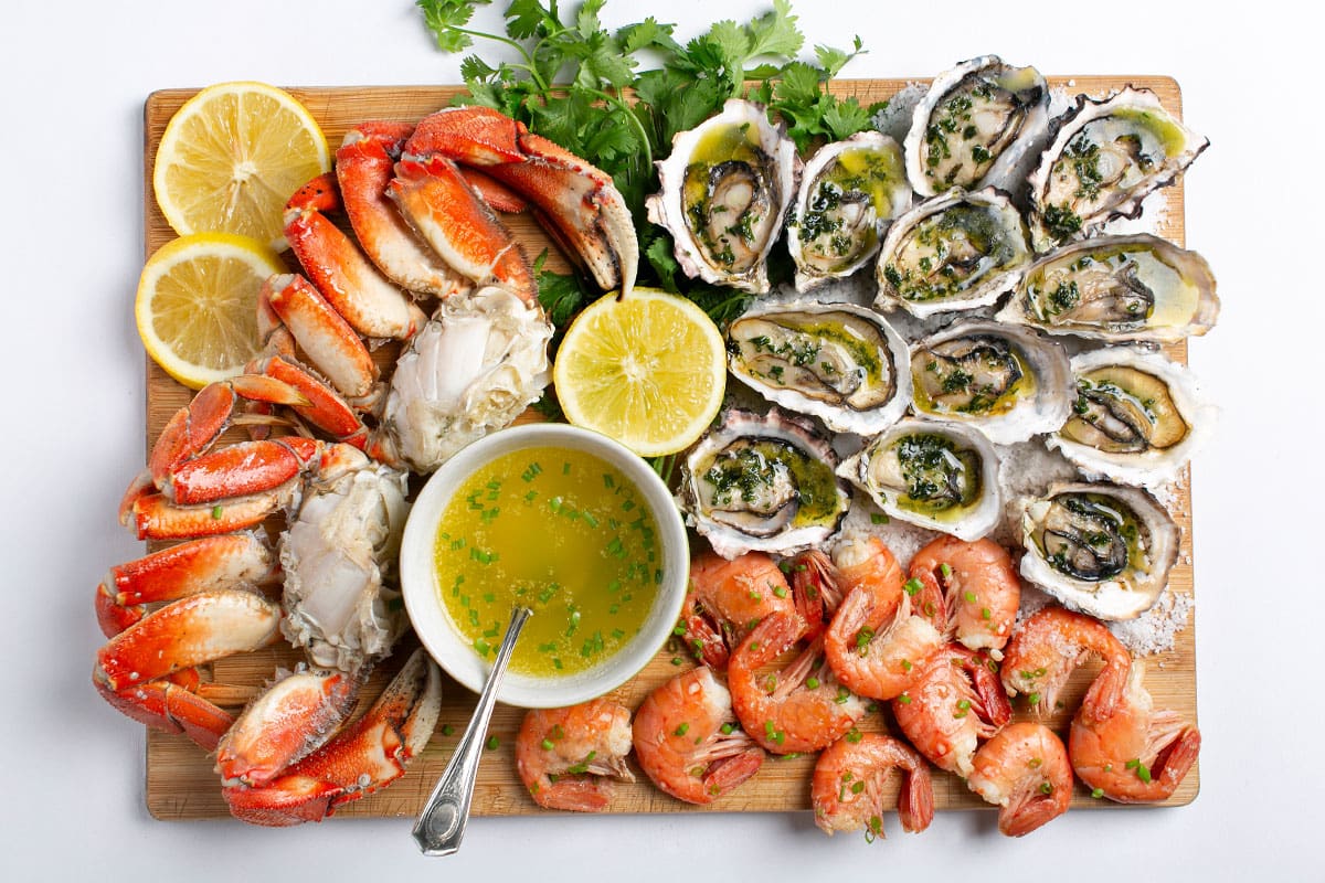 Assorted BC shellfish arranged on a platter, including spot prawns, Dungeness crab and Pacific oysters.